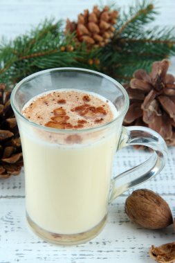 çam dalları ahşap zemin üzerinde yumurta likörü fincan