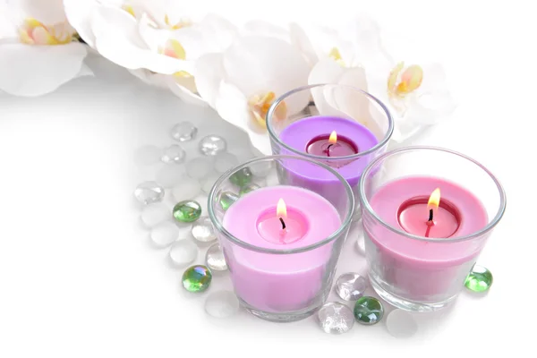 Beautiful colorful candles and orchid flowers, isolated on white — Stock Photo, Image