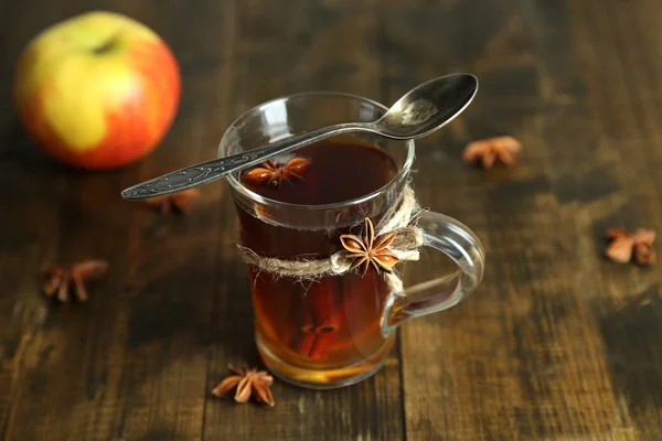 Warme drank in glas cup met vruchten en specerijen, op houten achtergrond — Stockfoto