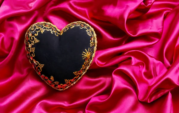 Decorative black heart, on color fabric — Stock Photo, Image