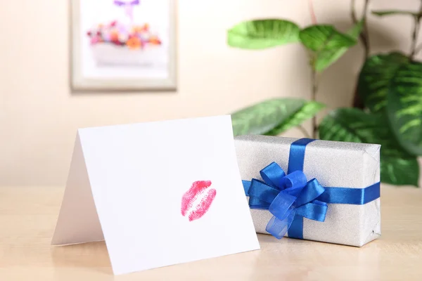 Hadiah dengan kartu untuk orang yang dicintai di atas meja di latar belakang kamar — Stok Foto
