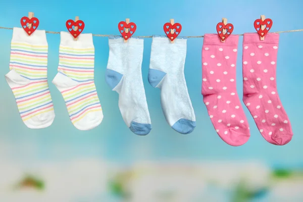 Socks hanging on clothesline on bright background — Stock Photo, Image