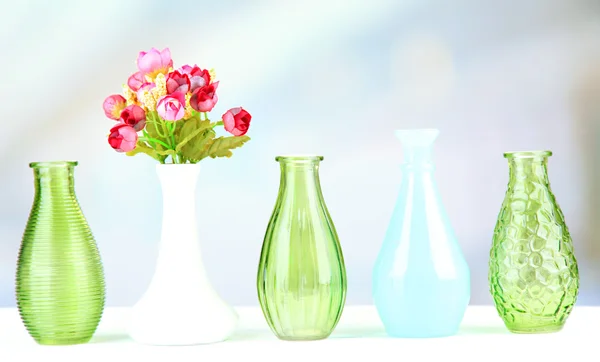 Different decorative vases on shelf on light background — Stock Photo, Image