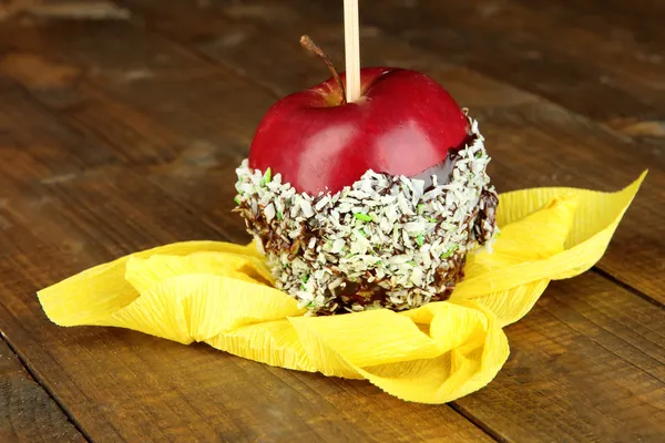 Candied apple on stick on wooden table — Stock Photo, Image