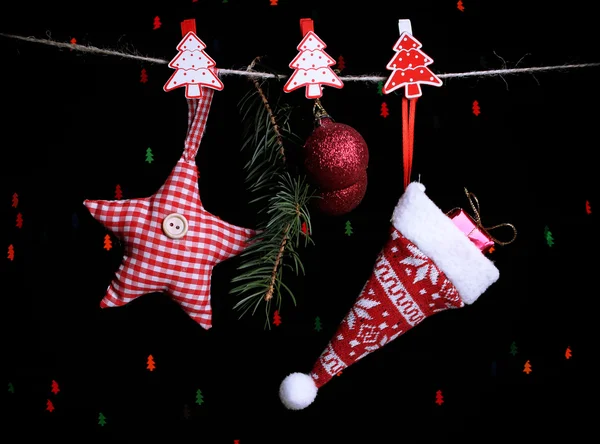 Weihnachtsmütze und weihnachtliche Accessoires auf schwarzem Hintergrund mit Lichtern — Stockfoto
