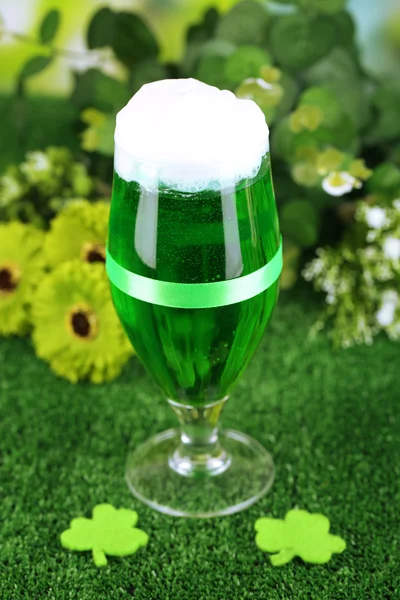 Glass of green beer for St Patricks day on grass close-up — Stock Photo, Image