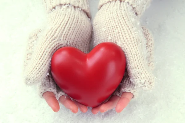 Mãos femininas em mitenes com coração vermelho, close-up — Fotografia de Stock