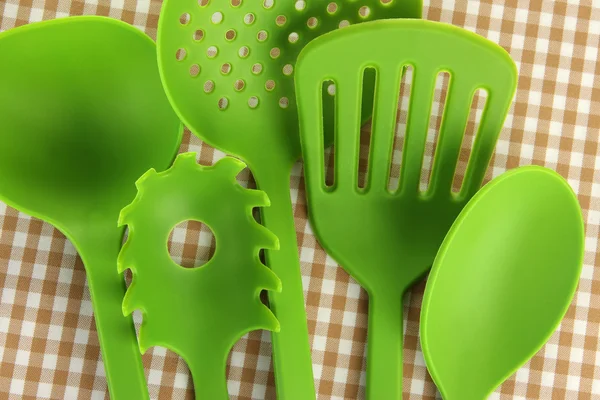 Utensili da cucina in plastica su sfondo tessuto — Foto Stock