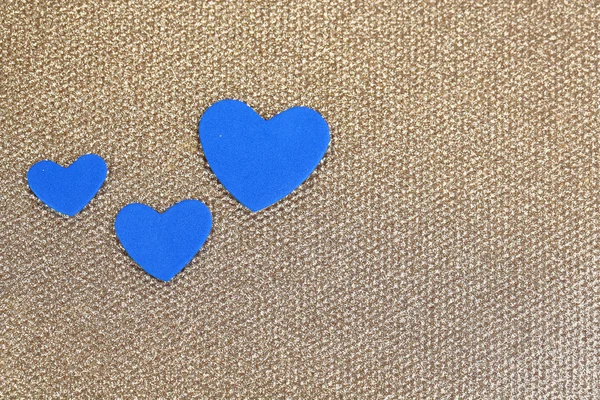 Blue hearts made of felt on golden background — Stock Photo, Image