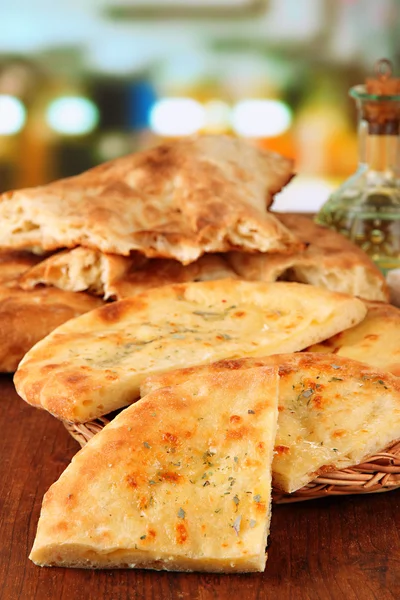 Pita breads on wooden stand with oil on table on bright background — Stock Photo, Image
