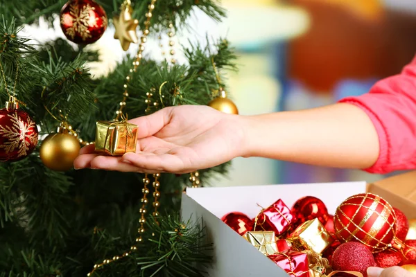 Decorating Christmas tree on bright background — Stock Photo, Image