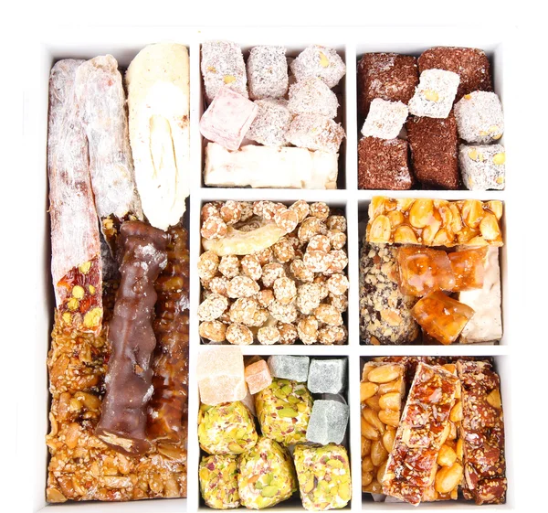 Gustosi dolci orientali in cassa di legno, isolati su bianco — Zdjęcie stockowe