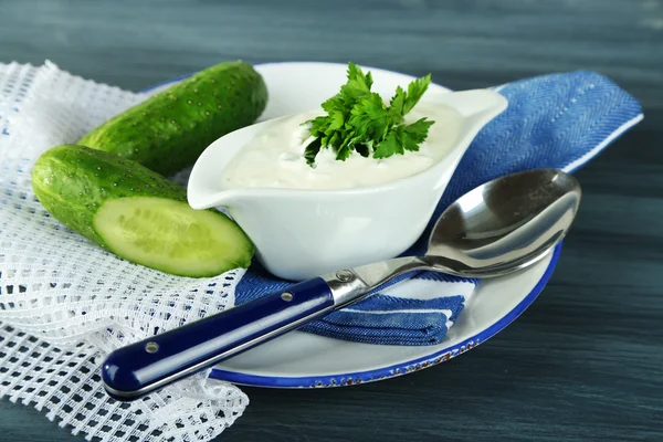 Yogur de pepino en bote de salsas, en servilleta de color, fondo de madera oncolor — Foto de Stock