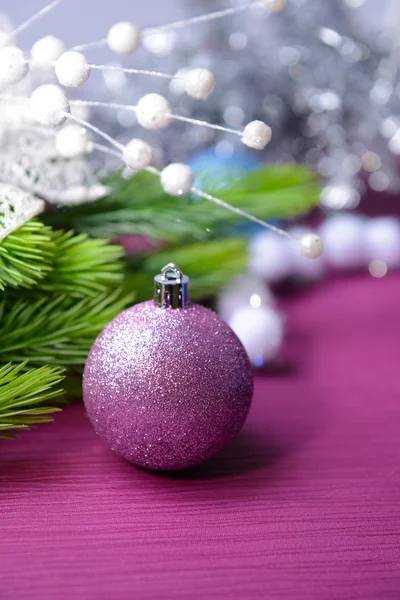 Kerstballen op fir boom, op een achtergrond met kleur — Stockfoto