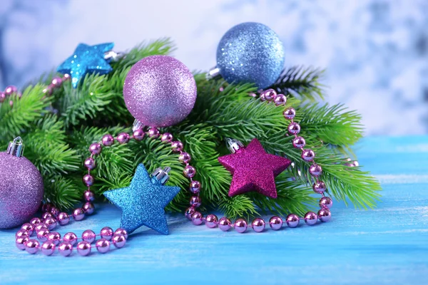 Christmas balls on fir tree, on color background — Stock Photo, Image