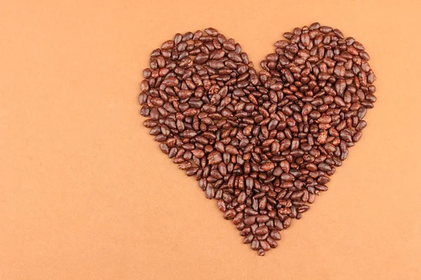 Coeur de grains de tournesol en chocolat, sur fond brun — Photo