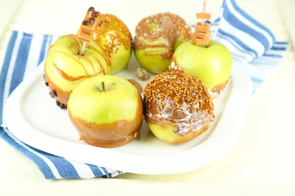 Homemade taffy apples, on napkin, on wooden background — Stock Photo, Image
