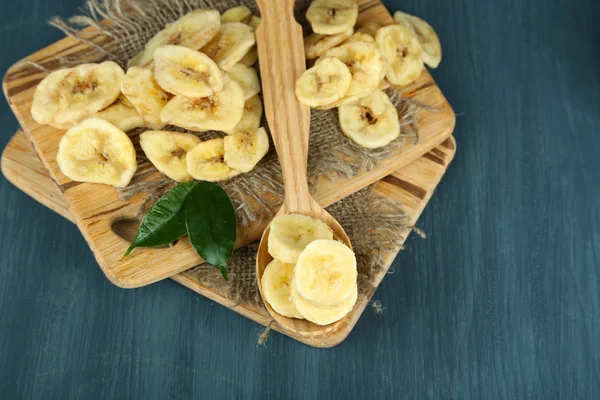 Čerstvé a sušené banánové řezy na prkénko, na dřevěné pozadí — Stock fotografie