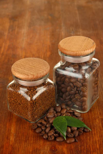 Jars of different coffee on wooden background — Stock Photo, Image
