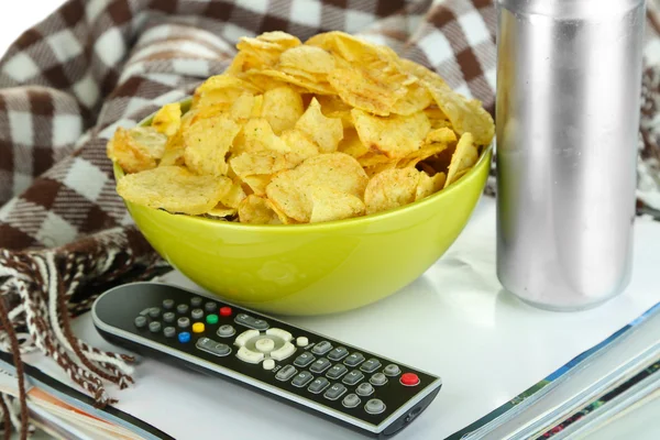 Chips in bowl, magazines, plaid and TV remote close-up — Stock Photo, Image