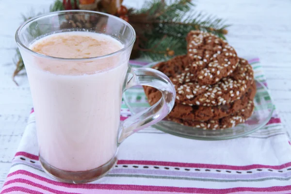 Cup of eggnog with cookie and fir branches on table close up — Stock Photo, Image