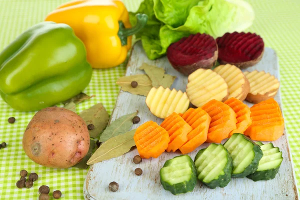 Renkli arka plan üzerinde kesme tahtası üzerinde güzel dilimlenmiş sebze — Stockfoto