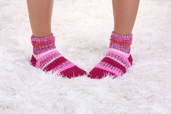 Female legs in colorful socks on white carpet background — Stock Photo, Image