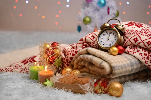 Složení s plédy, svíčky a vánoční ozdoby, na bílém koberci na světlé pozadí — Stock fotografie
