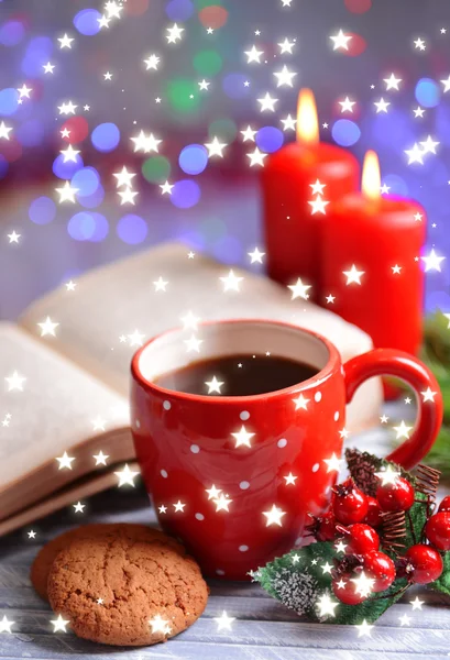 Состав книги с чашкой кофе и рождественскими украшениями на столе на ярком фоне — стоковое фото