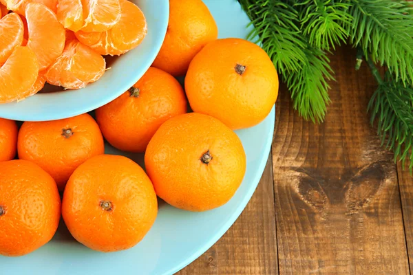 Mandarinas maduras en tazón con rama de abeto de cerca —  Fotos de Stock