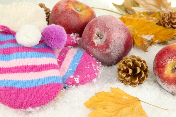 Rote Äpfel mit Fäustlingen im Schnee aus nächster Nähe — Stockfoto