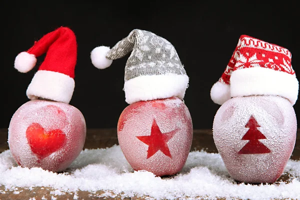 Holiday apples with frosted drawings on wooden table on black background — Stock Photo, Image