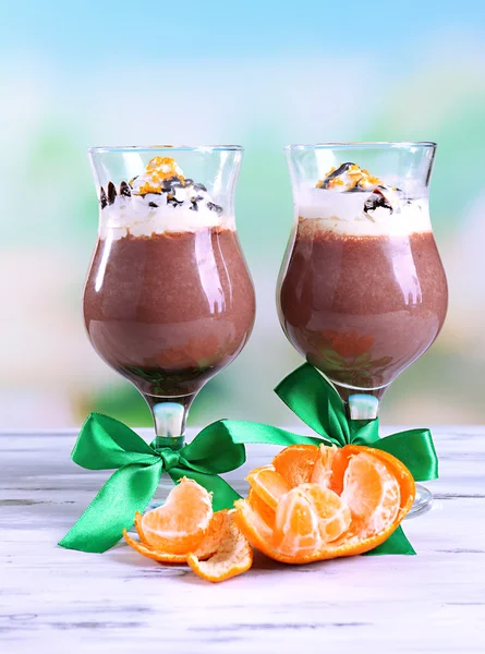 Sobremesa saborosa com chocolate, creme e molho de laranja, em guardanapo. na mesa de madeira, no fundo claro — Fotografia de Stock