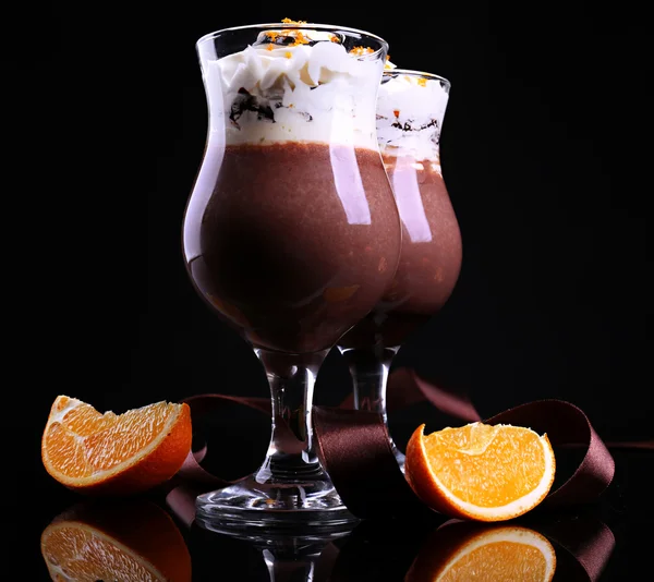 Sabroso postre con chocolate, crema y salsa de naranja, sobre fondo de color oscuro —  Fotos de Stock