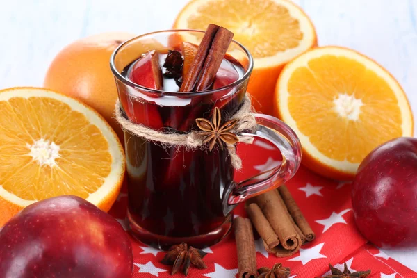 Fragrant mulled wine in glass on napkin and wooden table close-up — Stock Photo, Image