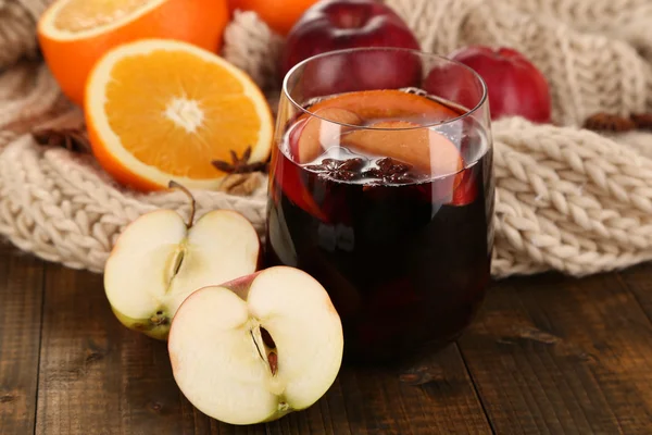 Fragrant mulled wine in glass on knitted scarf close-up — Stock Photo, Image