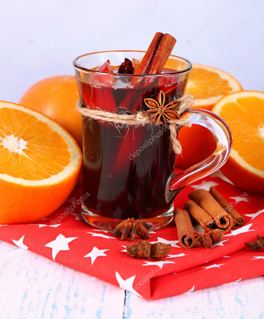 Fragrant mulled wine in glass on napkin on winter background