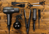 Hairdressing tools on wooden table close-up