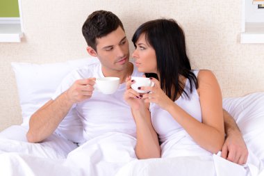 Çift yatakta kahve içmeyi seviyor