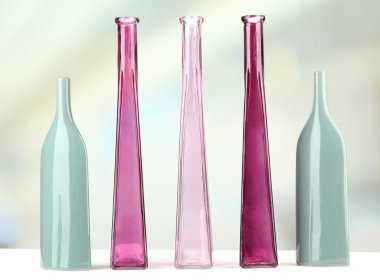 açık renkli raf üzerinde farklı dekoratif vazolar