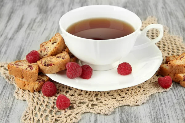 Kopje thee met koekjes en frambozen op tabel close-up — Stockfoto