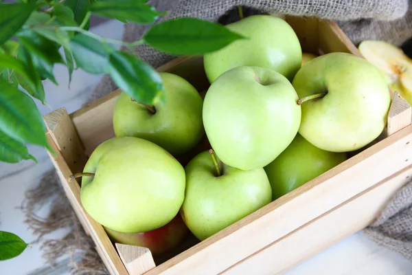 Juicy apples in box on wooden table — Stock Photo, Image