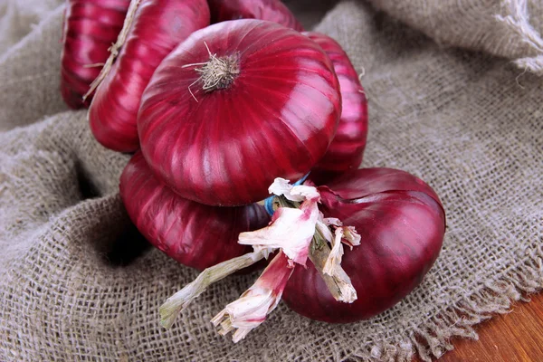 Cebollas rojas frescas en arpillera —  Fotos de Stock