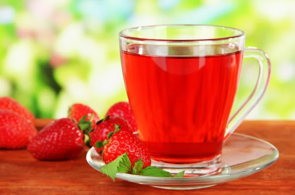 Delicioso té de fresa en la mesa sobre fondo brillante — Foto de Stock