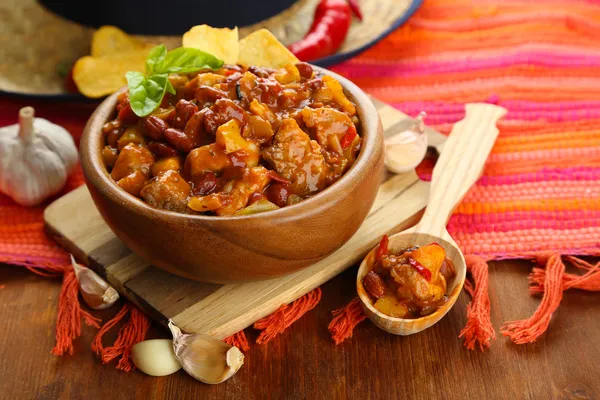 Chili Corn Carne - traditional mexican food, in wooden bowl, on napkin, on wooden background — Stock Photo, Image