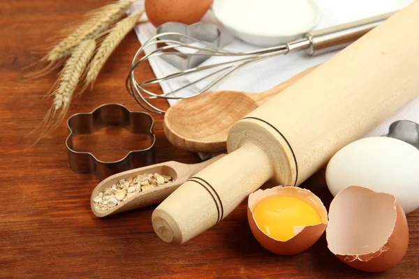 Koken concept. bakken basisingrediënten en keukengerei op houten tafel — Stockfoto