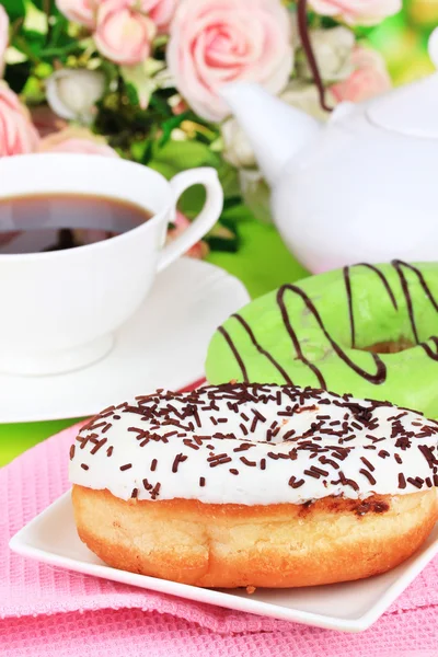 Zoete donuts met kopje thee op tabel close-up — Stockfoto