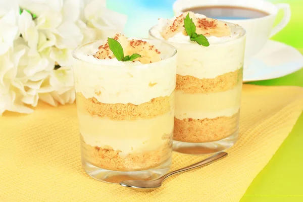 Delicioso postre con plátano y caramelo en la mesa sobre fondo brillante — Foto de Stock