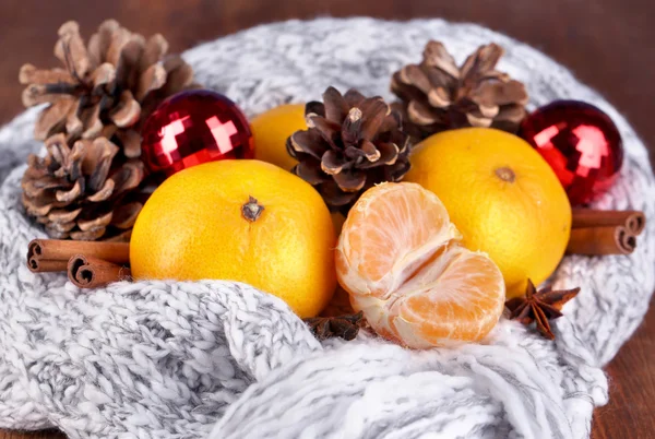 Natal tangerinas e brinquedos de Natal em malha cachecol close-up — Fotografia de Stock