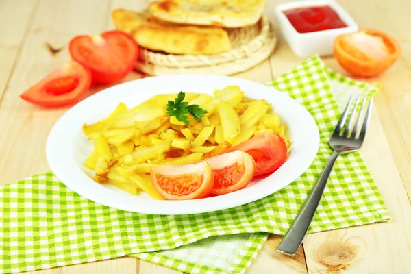 Patatas fritas en plato sobre mesa de madera primer plano —  Fotos de Stock